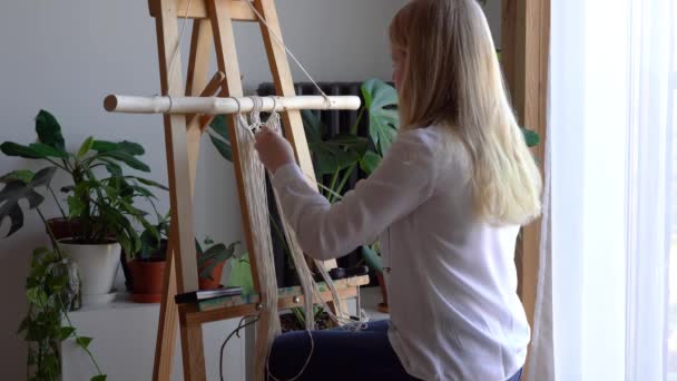 Reste à la maison. travail pendant la quarantaine - une fille dans le salon tissage mural des cordes dans la technique de macramé — Video