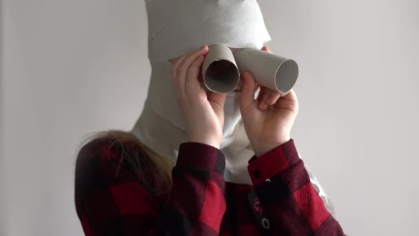 Grappige video - in quarantaine vanwege een epidemie van het coronavirus. meisje in een masker van toilet papier poseren op een grijze achtergrond. — Stockvideo