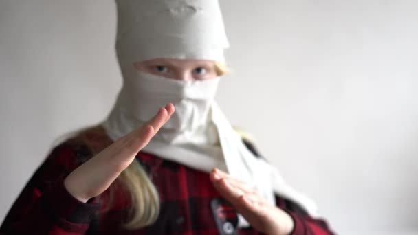 Funny video - quarantined due to an epidemic of coronavirus. girl in a mask from toilet paper posing on a gray background. — Stock Video