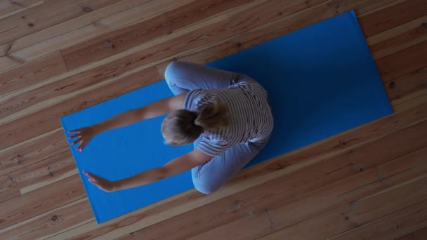 Stanna hemma. kvinna som gör yoga i vardagsrummet under karantän, stretching motion — Stockvideo