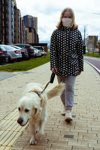 Koronavírus járvány a városban. lány séta egy golden retriever kutya végig üres utcákon — Stock Fotó