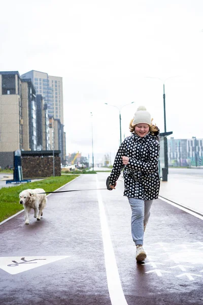 Coronavirus pandemic in the city. girl walking a golden retriever dog along empty streets — Stock Photo, Image