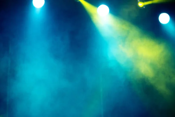 mavi, sarı ve yeşil renklerde bir duman ile ışık sahne