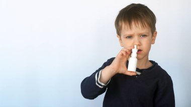 Çocuk nezleye karşı burnuna ilaç sıkıyor. Kendi kendini tedavi, burun spreyi, sağlık ve bakım konsepti.