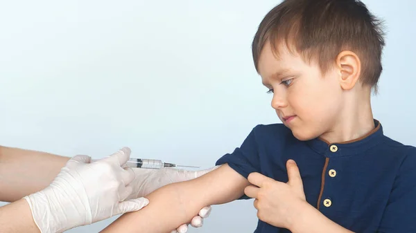 Očkování dětskou stříkačkou, vakcinační chlapeček. Doktor dát injekci chlapcům ruku Stock Fotografie