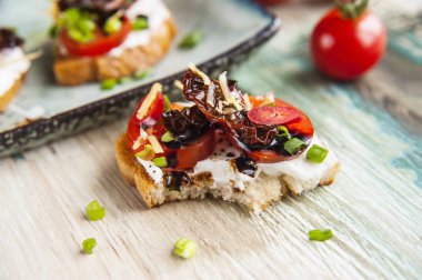 Bruschettes lor peynir, domates ve balzamik sos ile.