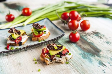 Bruschettes lor peyniri, domates, avokado ve balzamik sos ile.
