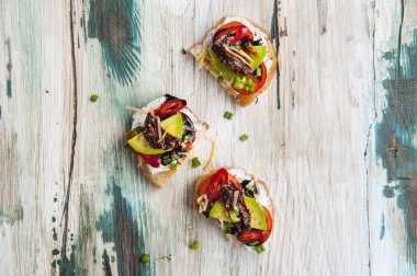 Bruschettes lor peyniri, domates, avokado ve balzamik sos ile.