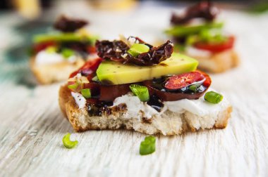Bruschettes lor peyniri, domates, avokado ve balzamik sos ile.