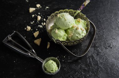 Fıstıklı dondurmalı beyaz karanlık bir arka plan üzerinde çikolata.