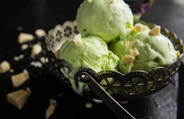 Fıstıklı dondurmalı beyaz karanlık bir arka plan üzerinde çikolata.