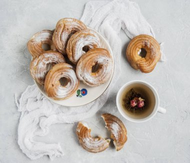 Süzme peynirli çörek çay ile pudra şekeri serpilir.