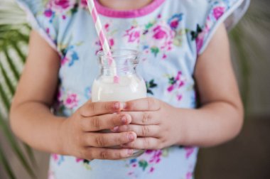Bir şişe süt bir çocuğun elinde.