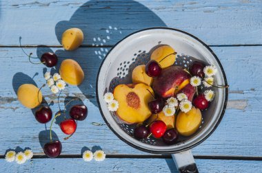 Summer peaches, apricots and cherries on a wooden table. clipart