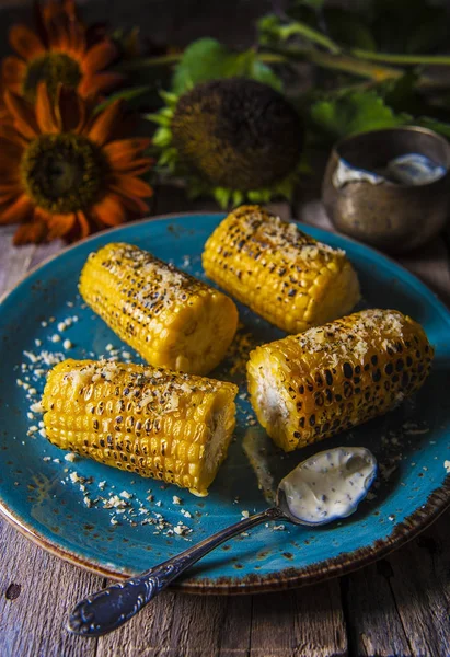Corn, baked on a grill Dinner Flowers on a wooden table — Stock Photo, Image