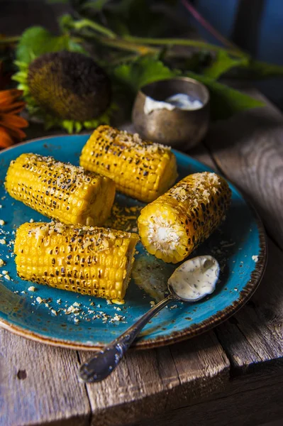 Mais, gebacken auf einem Grill, Blumen auf einem Holztisch — Stockfoto