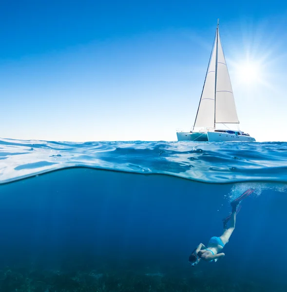 Jonge vrouw onder de boot snorkelen — Stockfoto