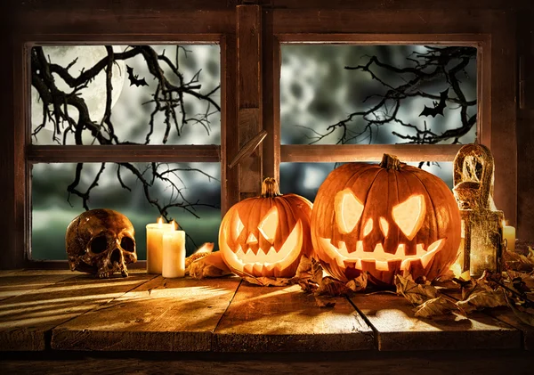 Gruselige Halloween-Kürbisse auf Holzplanken Stockfoto