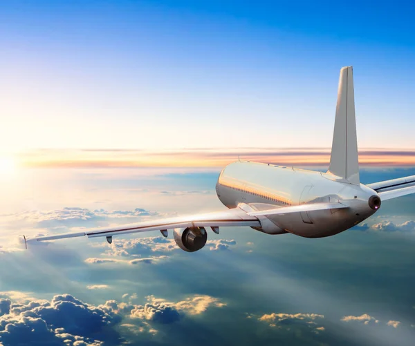 Avião voando acima das nuvens no pôr do sol dramático — Fotografia de Stock