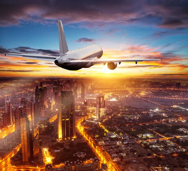 Commerciële vliegtuig vliegen over Dubai city — Stockfoto