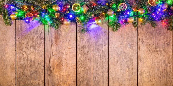 Weihnachtsbeleuchtung mit Dekoration auf Holz — Stockfoto