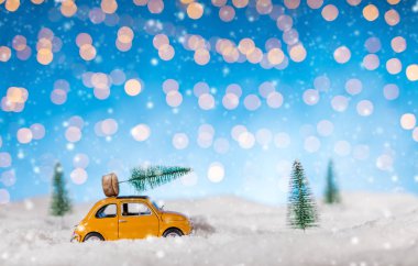 Bir Noel ağacı karda taşıyan minyatür araba