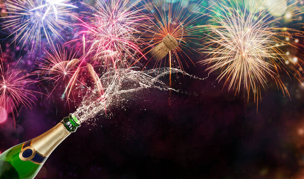 Бутылка шампанского на фоне фейерверков
