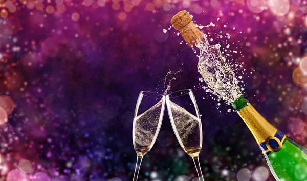 Bottle of champagne with glasses over fireworks background — Stock Photo, Image