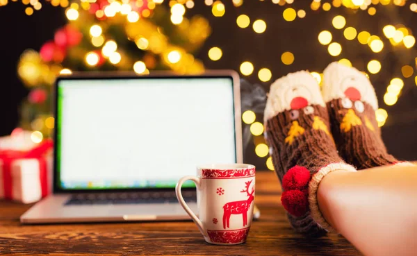 Woman legs and laptop with Christmas background — Stock Photo, Image
