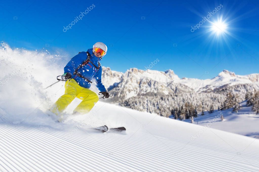 Skier on piste running downhill