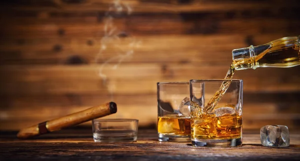 Glasses of whiskey with ice cubes served on wood — Stock Photo, Image
