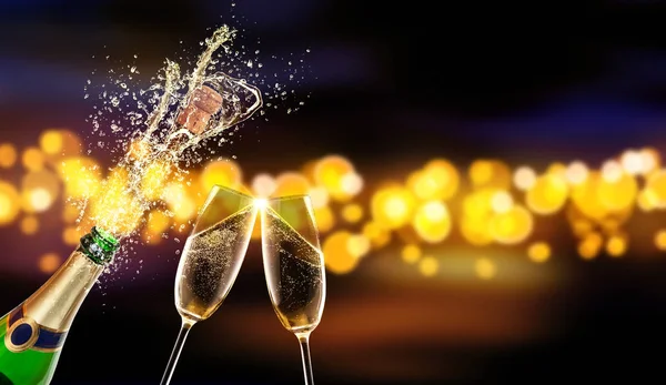 Fles champagne met glas over de achtergrond wazig — Stockfoto