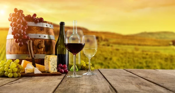 Red and white wine served on wooden planks, vineyard on background — Stock Photo, Image