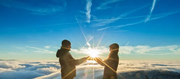 ผู้ชายและผู้หญิงที่มีดวงอาทิตย์อยู่ในมือ — ภาพถ่ายสต็อก