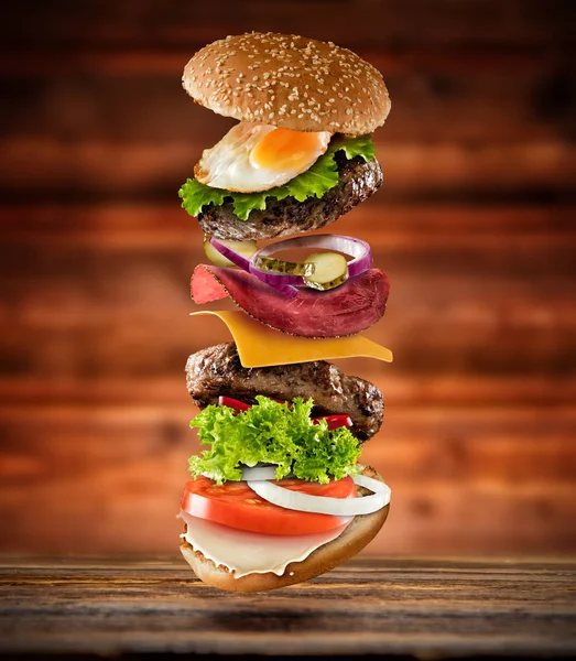 Maxi hamburger with flying ingredients — Stock Photo, Image