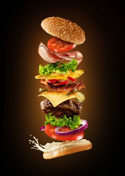 Maddeler koyu arka plan üzerinde uçan ile maxi hamburger