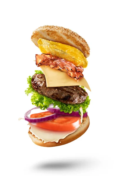 Maxi hamburguesa con ingredientes voladores sobre fondo blanco —  Fotos de Stock