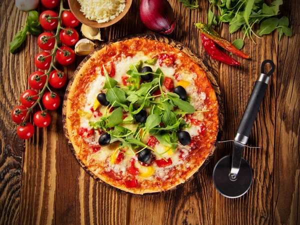 Pizza met ingrediënten geserveerd op hout — Stockfoto