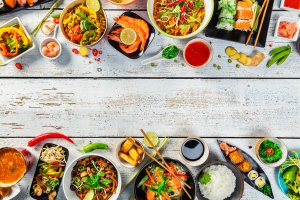 Asijské jídlo servírované na dřevěný stůl, pohled shora, prostor pro text — Stock fotografie