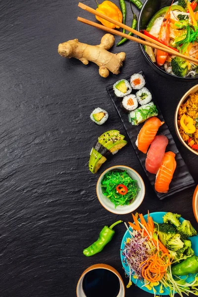 Asijské jídlo servírované na černý kámen, pohled shora, prostor pro text — Stock fotografie