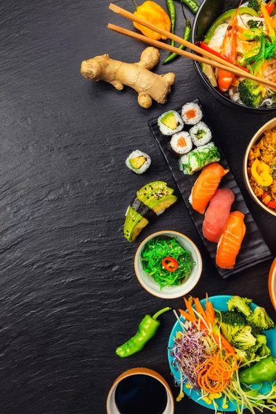 Asian food served on black stone, top view, space for text — Stock Photo, Image