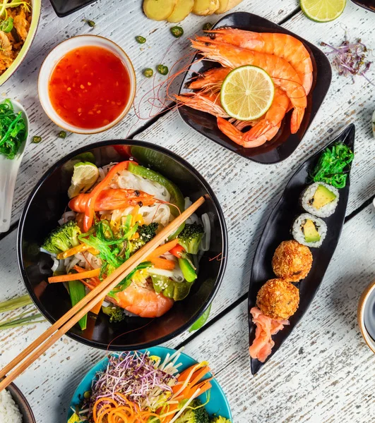 Asiatisk mat serveras på träbord, ovanifrån — Stockfoto