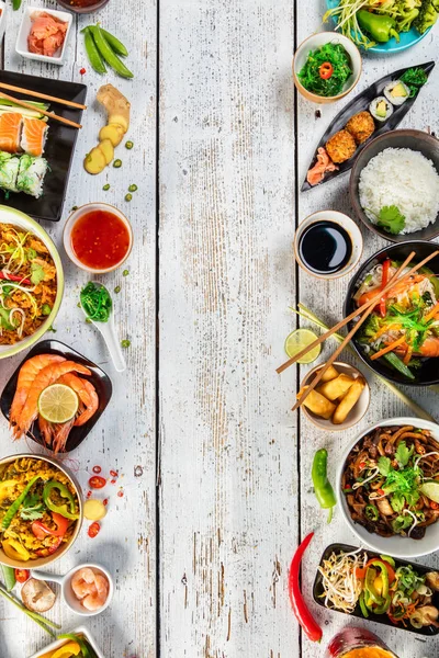 Asiatisk mat serveras på träbord, ovanifrån, utrymme för text — Stockfoto