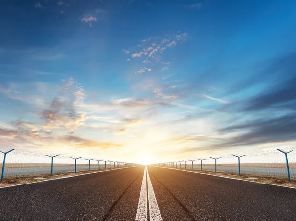 Pista o strada dell'aeroporto alla luce del tramonto di sera — Foto Stock