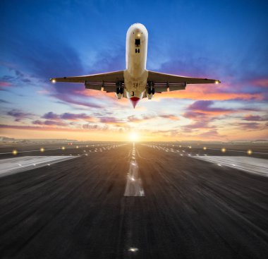 Airplane landing to airport runway in sunset light clipart