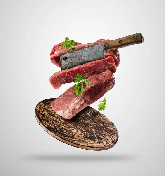 Flying raw steaks with ingredients, food preparation concept — Stock Photo, Image