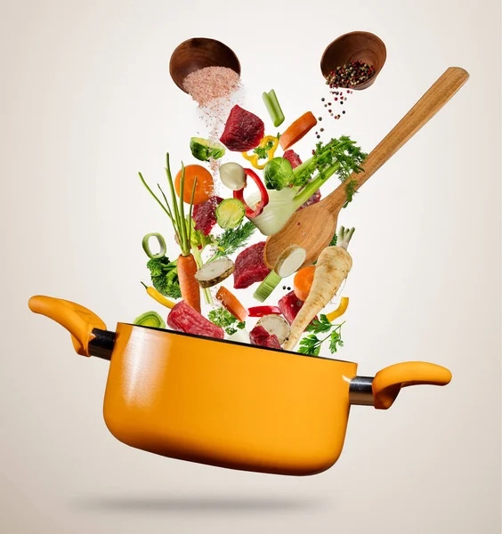 新鲜的蔬菜和肉在灰色的背景上飞入锅 — 图库照片