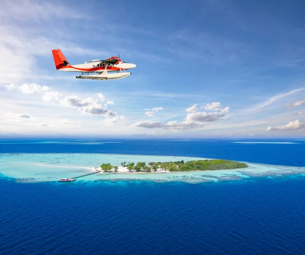 Avião-marinho voando acima de pequena ilha tropical em Maldivas — Fotografia de Stock