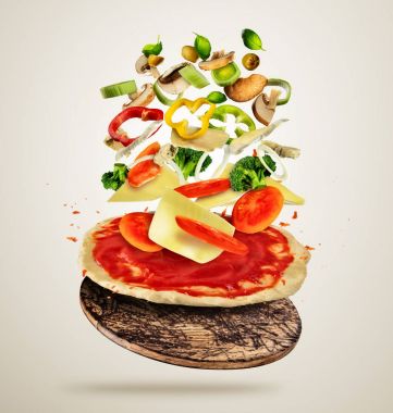 Pizza hamuru, kremsi arka plan üzerinde uçan malzemelerle