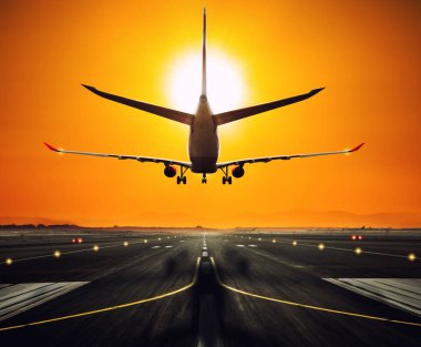 Silhouette from a landing airplane at the runway. clipart